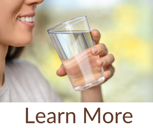 A woman holding a glass of water with the words lean more